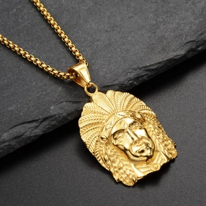 Detailed macro view of golden Indian chief portrait pendant on a textured dark rock base