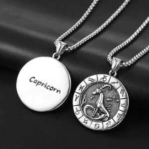 Vue macro du collier pendentif Capricorne en acier inoxydable argenté sur fond noir
