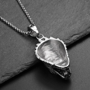 Detail of hiphop wolf head pendant in silver finish on textured black stone