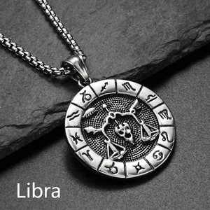 Détail macro du pendentif Balance en acier inoxydable argenté sur fond de pierre grise