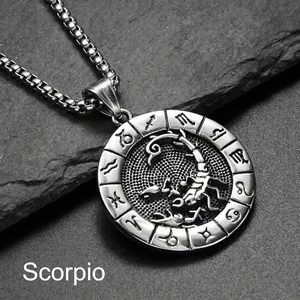 Vue macro du pendentif Scorpion en acier argenté avec chaîne sur roche sombre