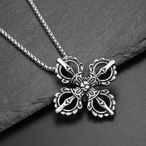 Detailed macro view of vintage silver cross vajra pendant with box chain on dark stone