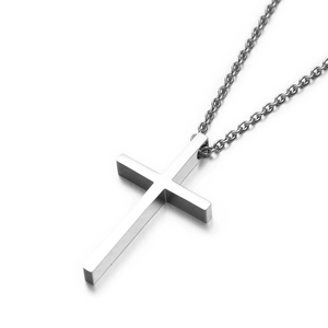 Gros plan d'un pendentif croix en acier inoxydable poli avec finition argentée sur une chaîne