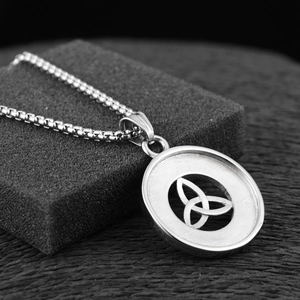 Macro shot of silver titanium steel necklace featuring a hollow Celtic knot round pendant