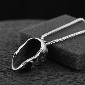 Gros plan sur le pendentif crâne en argent vieilli avec une chaîne de style boîte