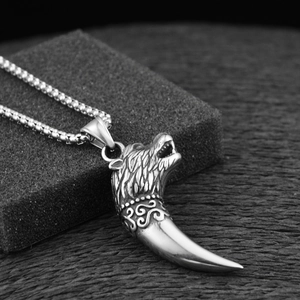 Vue macro du pendentif tête de loup et dent en acier avec texture de poils détaillée