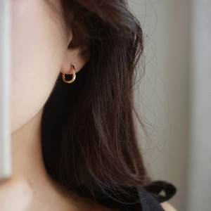 Pendientes de aro retorcidos en forma de gota dorada para mujer en primer plano de perfil