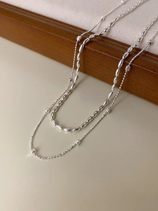 Detail of S925 sterling silver sugar cube necklace draped on a wooden frame