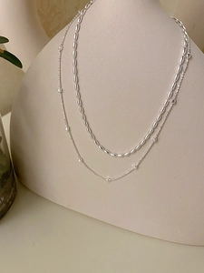 Detail view of S925 sterling silver layered necklace with square and oval bead charms