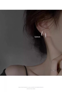 Primo piano di orecchini a cerchio da 12mm in argento con zirconi su una modella