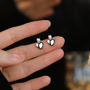 Elegant S925 silver heart stud earrings with round white pearls held between fingers