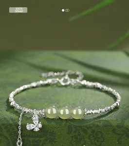 Detail of S925 sterling silver bracelet with green jade beads and a butterfly charm