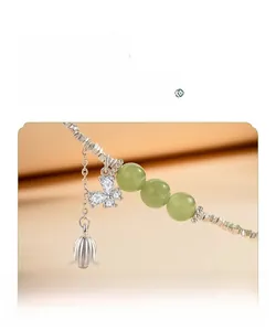 Detail of silver lily-of-the-valley bracelet with butterfly pendant and green jade beads