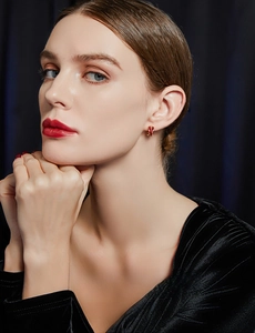 Close-up of French vintage red earrings with golden texture on a female model