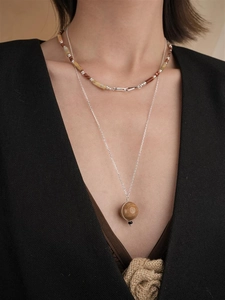 Detail der zweilagigen Saturn-Halskette mit braunen Tigerauge-Perlen und silberner Kette