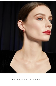 Close-up of a model wearing French vintage red enamel X-shaped stud earrings
