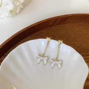 Détail du clou coeur doré et du pendentif papillon en émail blanc avec zircon