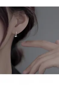 Gros plan d'une boucle d'oreille minimaliste en argent S925 avec pendentif en zircon