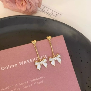 Élégantes boucles d'oreilles cœur doré avec nœud papillon blanc et pierre de zircon