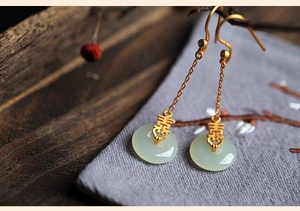 Vue macro des boucles d'oreilles Xi en or traditionnel avec boucle Pingan en jade