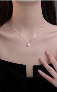Elegante minimalistische parelketting met zilveren ketting om de nek van het model