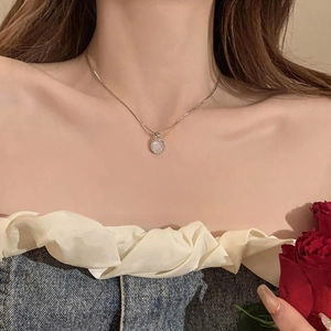 Elegant moonstone pendant necklace with silver chain on model, minimalist 2024 jewelry design