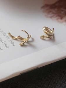 Detailed close-up of gold snake hoop earrings featuring the S925 sterling silver hallmark