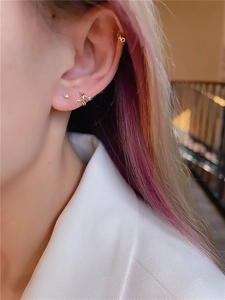 Detailed close-up of a layered gold snake-shaped ear cuff set with shiny cubic zirconia