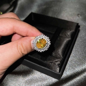 Vista macro de un anillo de lujo con gema amarilla de corte ovalado y engaste halo doble