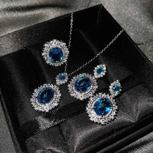 Primer plano de conjunto de joyas de lujo con piedras de topacio azul y halo de diamantes