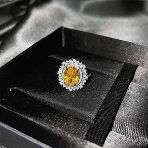 Vista macro de un anillo de lujo con citrino amarillo y doble halo de diamantes en estuche