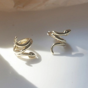 Golden snake-shaped hoop earrings with a spiral wrap design and polished finish