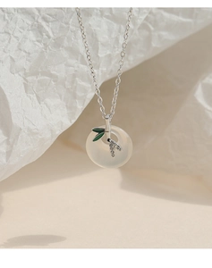 Detail of 925 silver necklace with white jade pendant and green bamboo branch accents