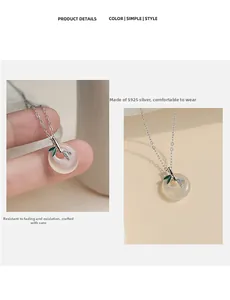 Detail of S925 silver bamboo leaf pendant with white jade-like stone and green enamel