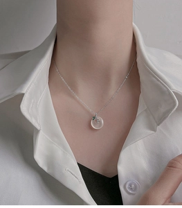 Close-up of 925 sterling silver necklace with white translucent jade ping an kou pendant