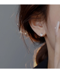Close-up of a silver spherical stud earring featuring a bright round-cut cubic zirconia