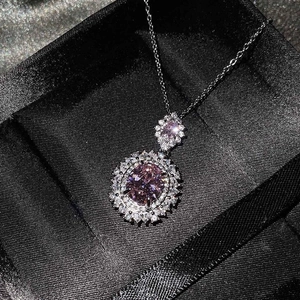 Detalle de collar con colgante de gema rosa ovalada y doble engaste halo de diamantes