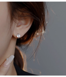 Macro shot of silver stud earring featuring a central round zircon and small pave accents