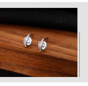 Macro shot of silver spherical zircon stud earrings with a sparkling planetary ring design