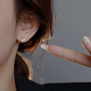 Elegant sphere zircon stud earrings in polished silver finish worn on model ear