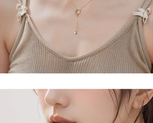 Detailed close-up of golden Y-shaped tassel necklace with crystal pavé circle and droplet