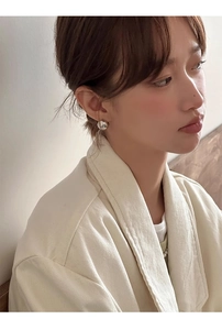 Gros plan d'une boucle d'oreille boule en argent avec finition miroir sur un mannequin