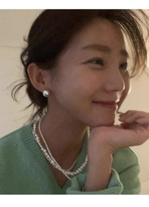 Gros plan de boucles d'oreilles perles blanches et collier de perles sur un modèle