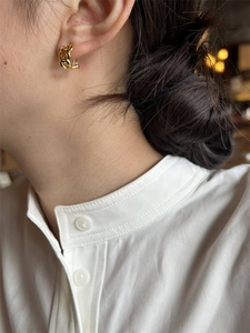 Mannequin portant des boucles d'oreilles créoles dorées avec un design en chaîne chic