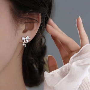 Exquisite white zircon bowknot stud earrings with hanging star charms on model