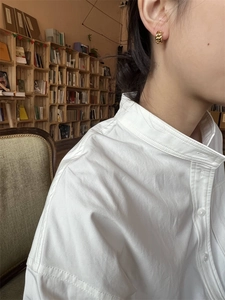 Vue détaillée d'une boucle d'oreille créole dorée à maillons portée par un mannequin en studio