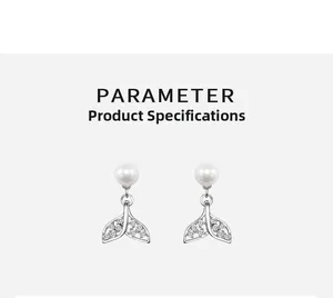 Detail view of pearl earrings with zircon fishtail drops on a clean grey background