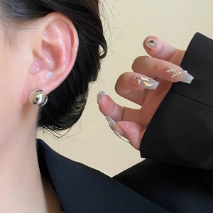 Boucles d'oreilles boules en argent minimalistes avec finition miroir sur mannequin