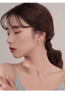 Detail of fishtail pearl earring with cubic zirconia pavé on an elegant woman