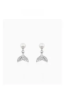 Detailed macro view of silver fishtail stud earrings with white pearls and micro zircons